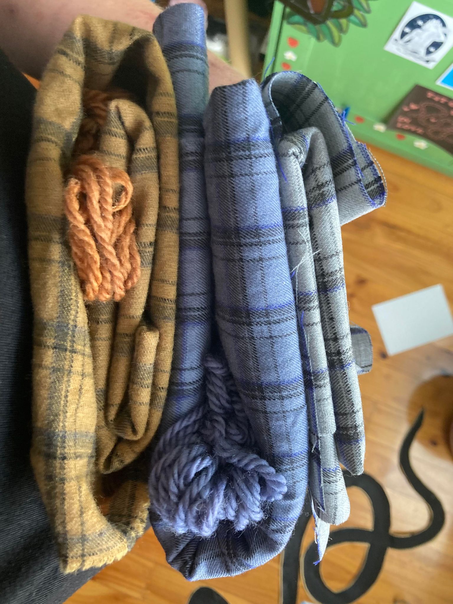 Folded fabric comparing the undyed, orange and blue plaid fabrics.